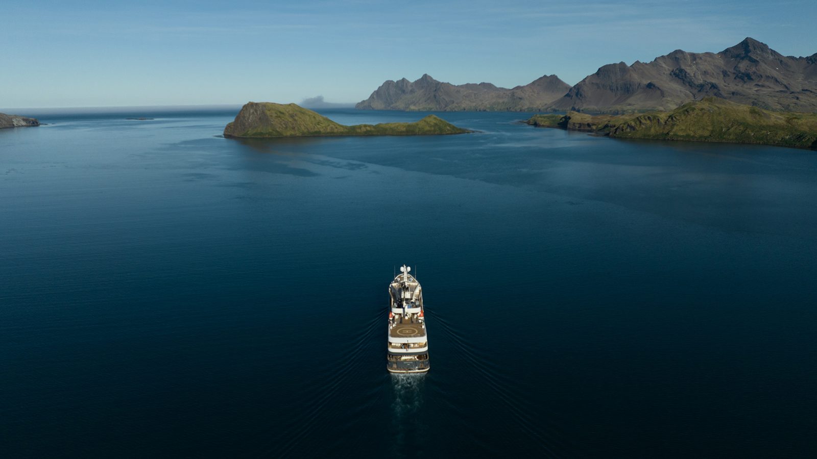 Yacht approaching a remote island coastline